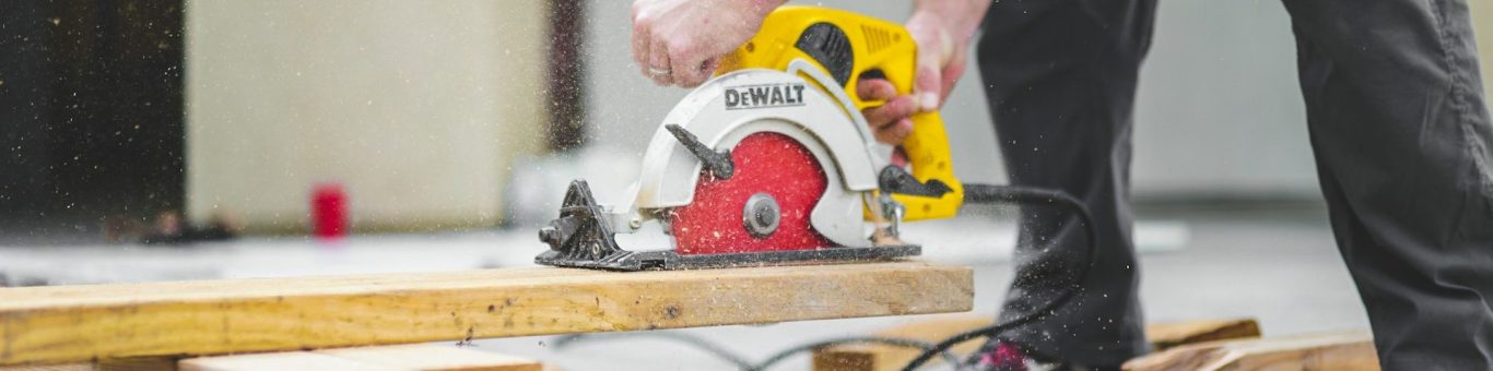 Zaagwerkzaamheden Een persoon gebruikt een cirkelzaag op een houten plank.