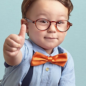 Ok Jongentje met bril en een oranje strik, geeft een duim omhoog.